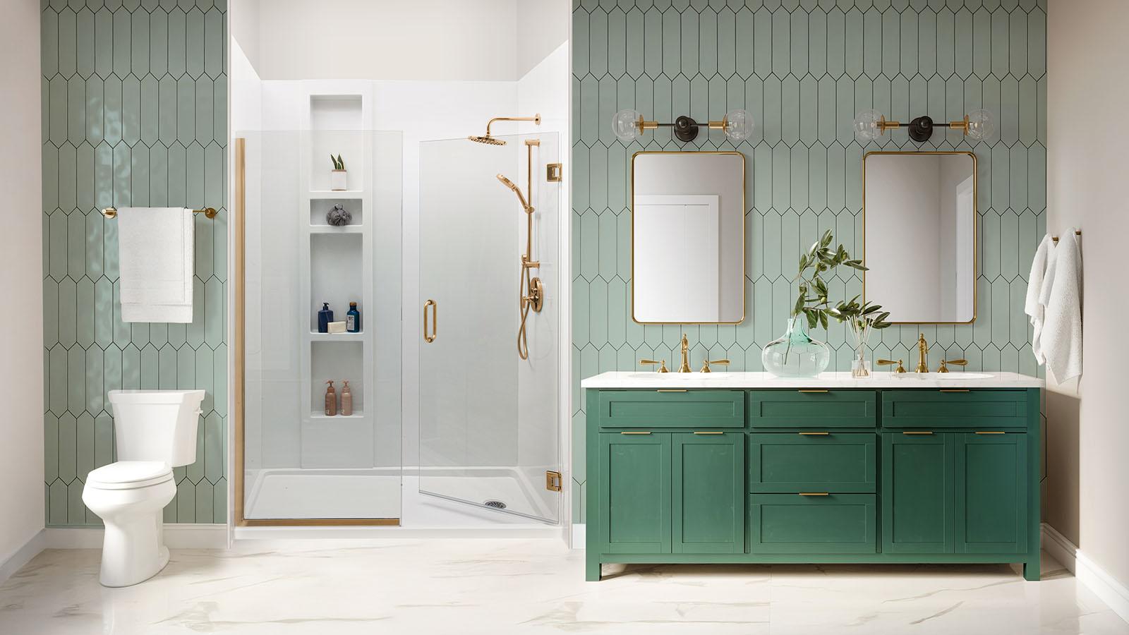 Modern accessible bathroom featuring walk-in shower with white tile, geometric seafoam green wall tiles, gold fixtures, green vanity with dual sinks, gold-framed mirrors, and white toilet showing barrier-free design